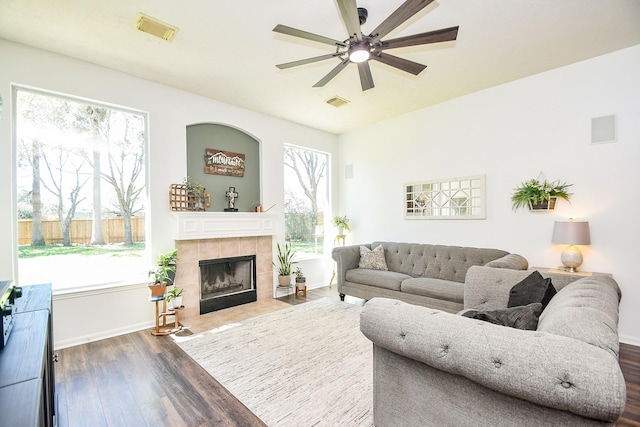 living area with dark wood finished floors, visible vents, and plenty of natural light