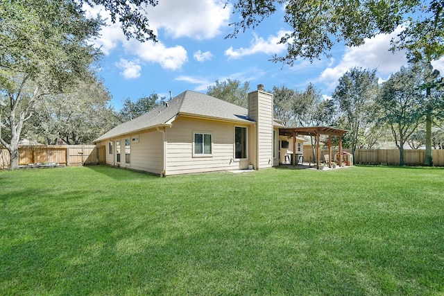 back of house with a patio area, a fenced backyard, a chimney, and a yard