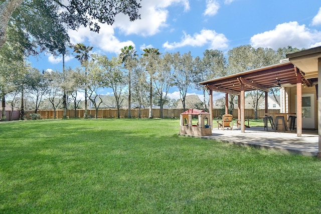 view of yard featuring a patio, a fenced backyard, and a ceiling fan