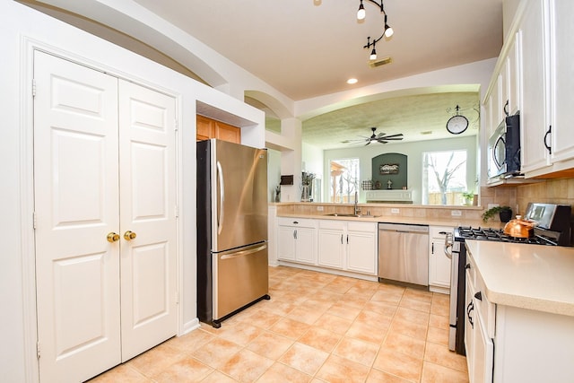 kitchen featuring stainless steel appliances, a sink, visible vents, light countertops, and backsplash