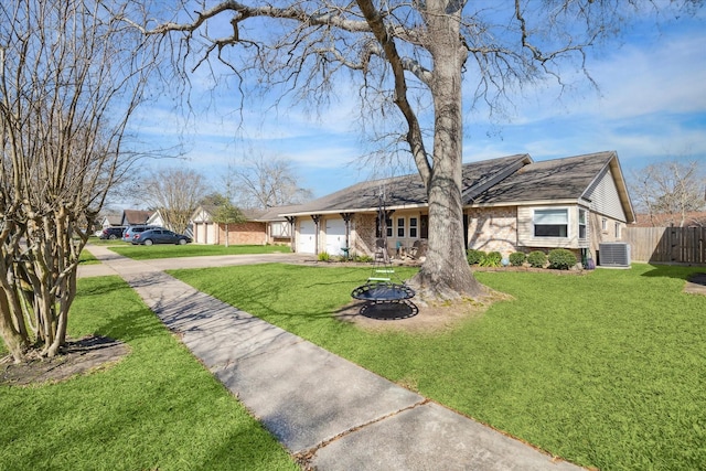 view of front of house featuring brick siding, concrete driveway, fence, central AC, and a front yard