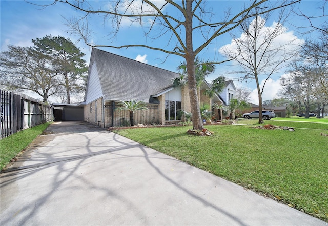 view of home's exterior with fence, roof with shingles, a yard, concrete driveway, and brick siding