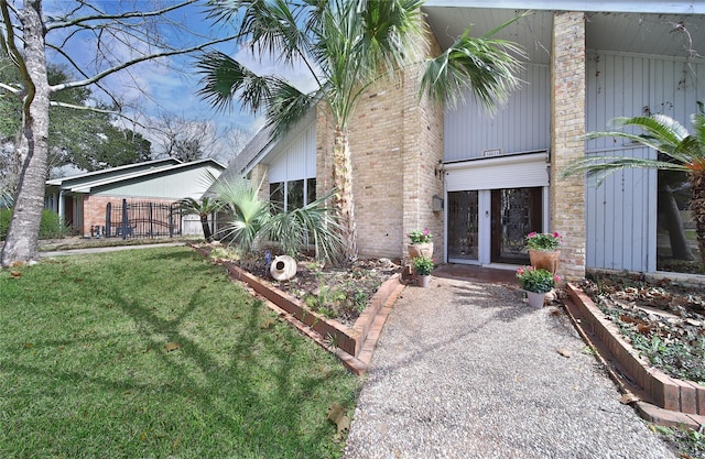 exterior space with brick siding and a front lawn