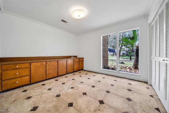 unfurnished room featuring a sink, visible vents, and ornamental molding