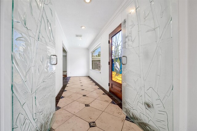 hall featuring baseboards, visible vents, recessed lighting, ornamental molding, and tile patterned floors