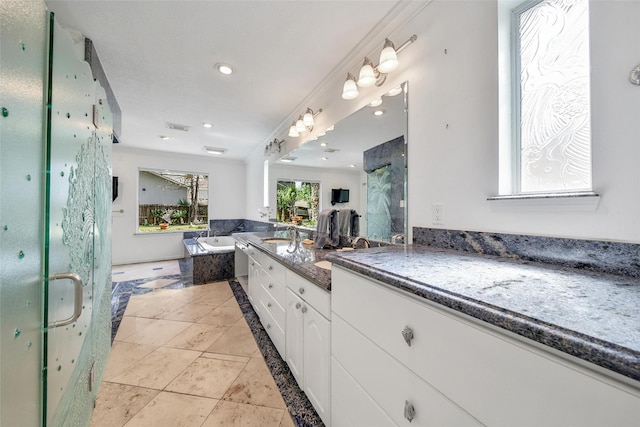 kitchen with recessed lighting, open floor plan, white cabinets, and a sink