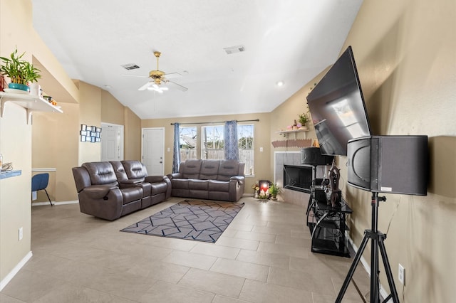 living room with lofted ceiling, ceiling fan, visible vents, and a tile fireplace