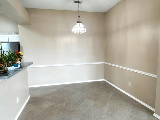 unfurnished dining area with baseboards, visible vents, and a chandelier