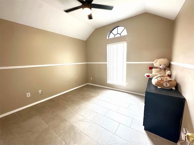 empty room featuring baseboards, lofted ceiling, and ceiling fan