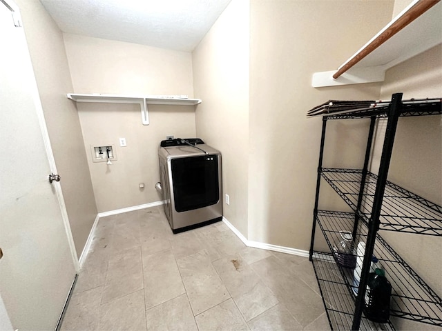 clothes washing area with washer / clothes dryer, baseboards, and laundry area