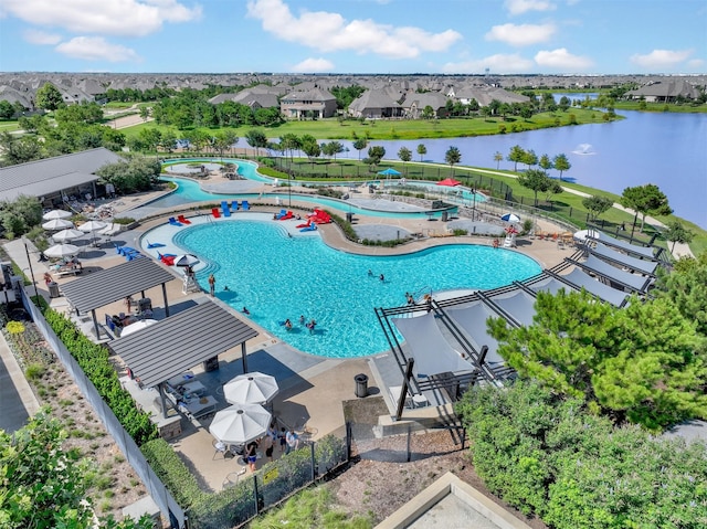 community pool with a patio, a water view, and fence