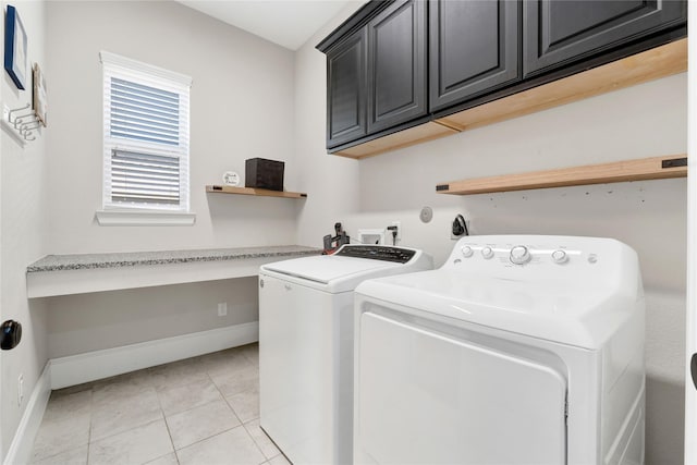 laundry area featuring separate washer and dryer, light tile patterned flooring, cabinet space, and baseboards