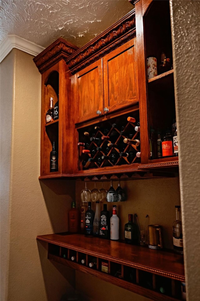 wine cellar with a textured ceiling, a textured wall, and a dry bar