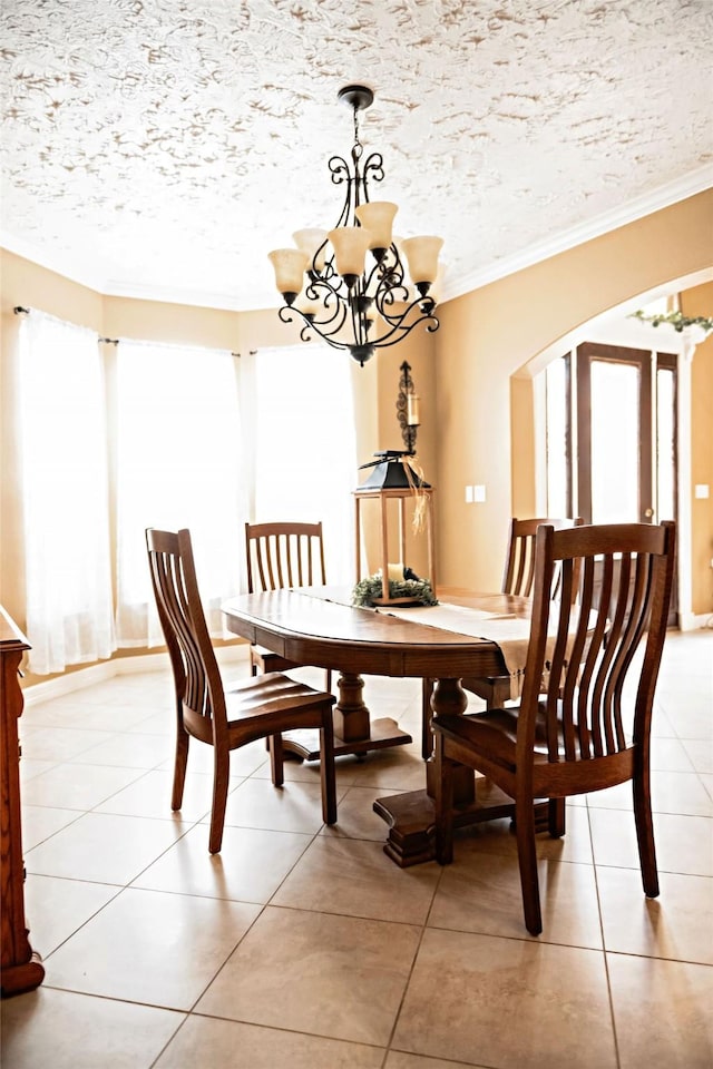 dining area with a chandelier, arched walkways, crown molding, and a textured ceiling