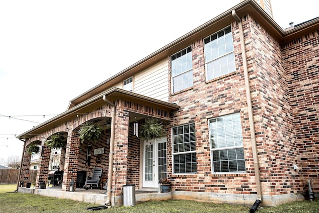 back of property featuring a ceiling fan, a patio area, and brick siding