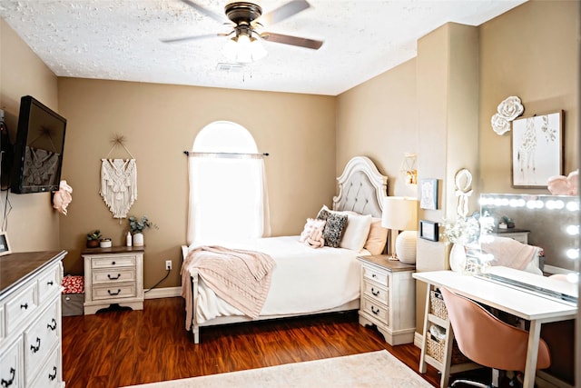 bedroom featuring dark wood-style floors, visible vents, a ceiling fan, a textured ceiling, and baseboards