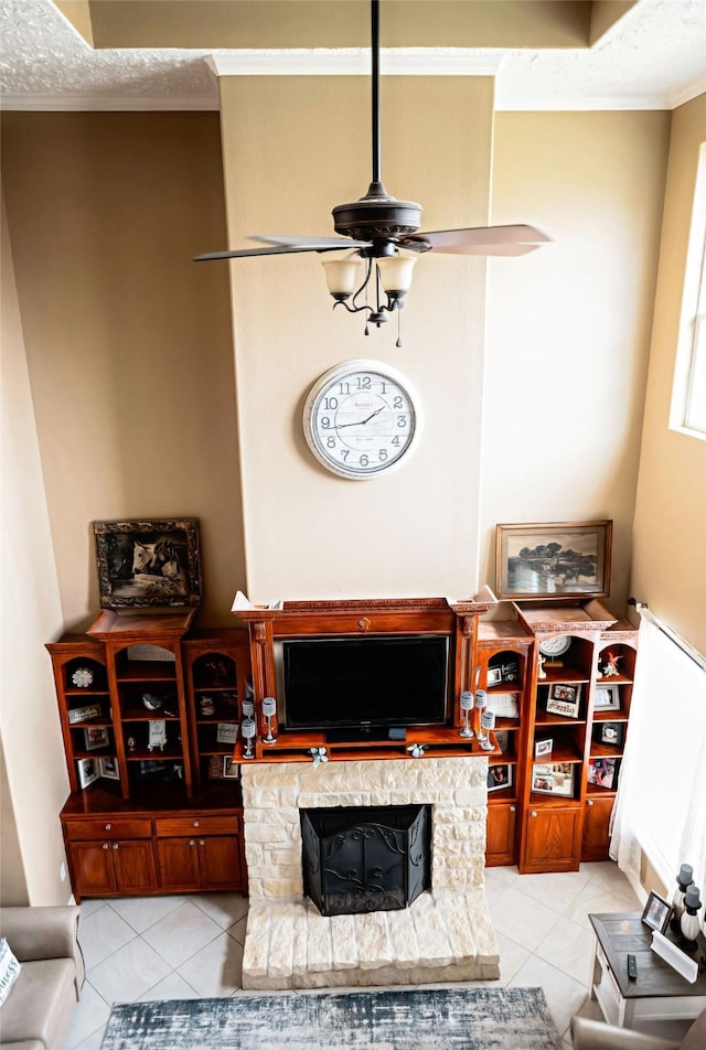 living area with ornamental molding, a fireplace, ceiling fan, and light tile patterned flooring