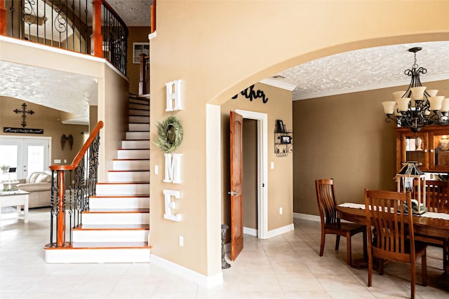 interior space with arched walkways, french doors, a notable chandelier, crown molding, and stairway