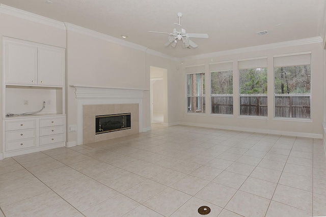 unfurnished living room featuring crown molding, a fireplace, light tile patterned floors, visible vents, and ceiling fan