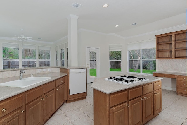 kitchen with white appliances, visible vents, decorative backsplash, ornamental molding, and a sink