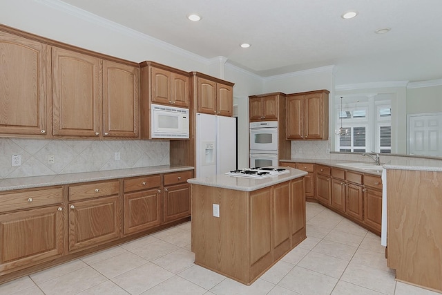 kitchen with light tile patterned floors, white appliances, a sink, and crown molding