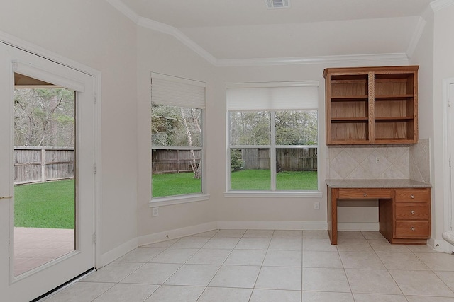 unfurnished office with vaulted ceiling, light tile patterned flooring, baseboards, and crown molding