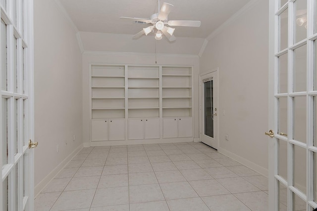 unfurnished room featuring a ceiling fan, crown molding, baseboards, and light tile patterned floors