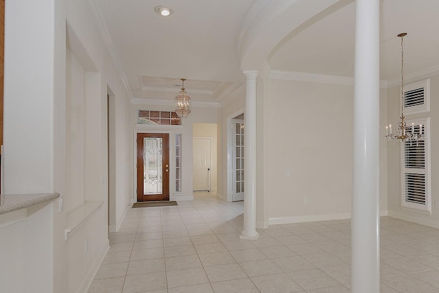 entrance foyer with ornate columns, light tile patterned floors, an inviting chandelier, and crown molding