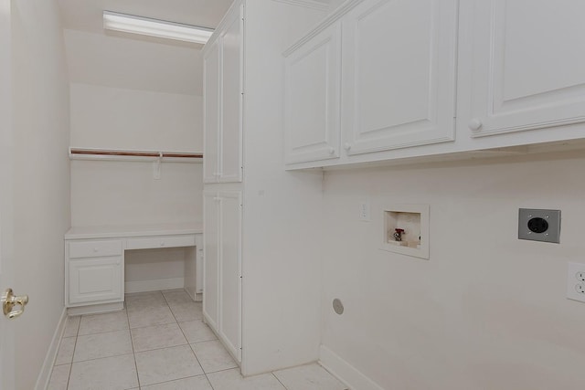 laundry room featuring cabinet space, baseboards, hookup for a washing machine, electric dryer hookup, and light tile patterned flooring