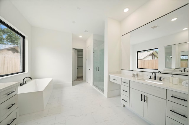 full bathroom with marble finish floor, a stall shower, a soaking tub, and recessed lighting