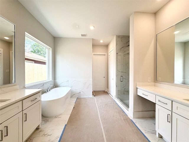 1953 Coulcrest Dr, Houston, TX 77055 - full bathroom with marble look tile flooring, a marble finish shower, two vanities, a freestanding tub, and recessed lighting