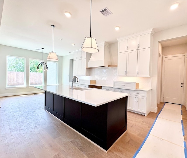 1953 Coulcrest Dr, Houston, TX 77055 - kitchen featuring premium range hood, a sink, white cabinetry, light wood-style floors, and recessed lighting