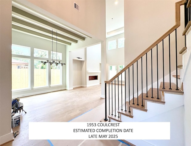 1953 Coulcrest Dr, Houston, TX 77055 - stairs featuring healthy amount of natural light, a towering ceiling, wood finished floors, and a chandelier