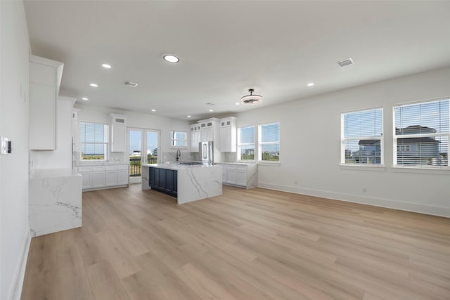 kitchen featuring a healthy amount of sunlight, light wood-style floors, and white cabinetry