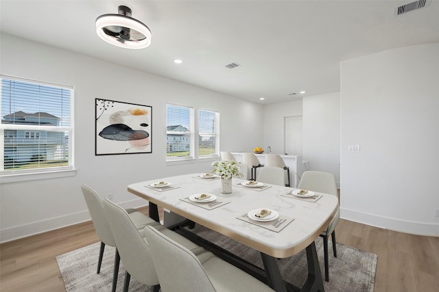 dining room featuring baseboards, visible vents, and light wood finished floors