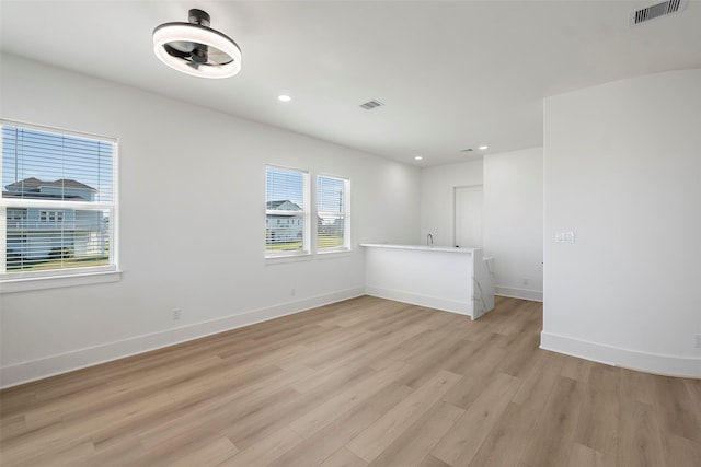 empty room with light wood-type flooring, baseboards, visible vents, and recessed lighting