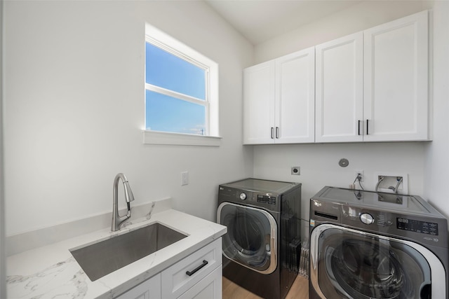 laundry area with cabinet space, a sink, and washing machine and clothes dryer