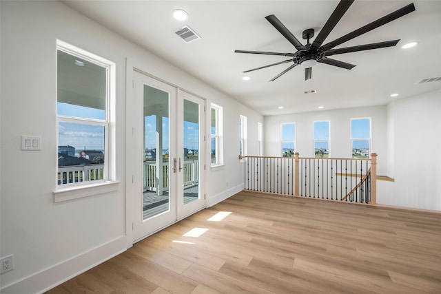 empty room with french doors, visible vents, and light wood finished floors