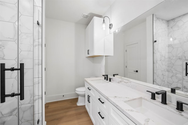 full bath with wood finished floors, a sink, and a marble finish shower