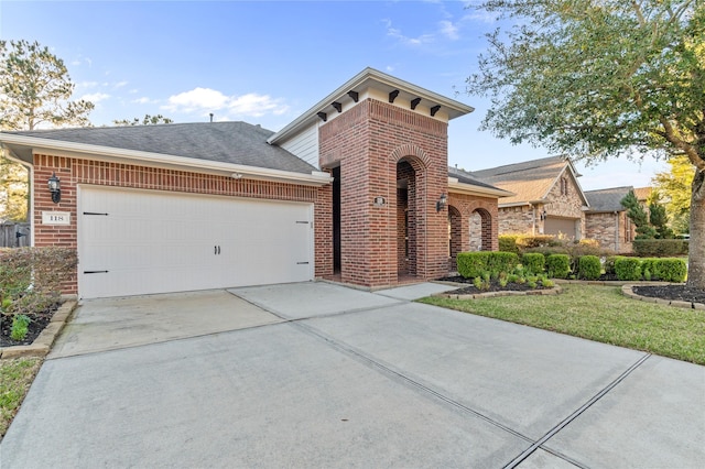 view of front of house featuring a front lawn, concrete driveway, brick siding, and an attached garage