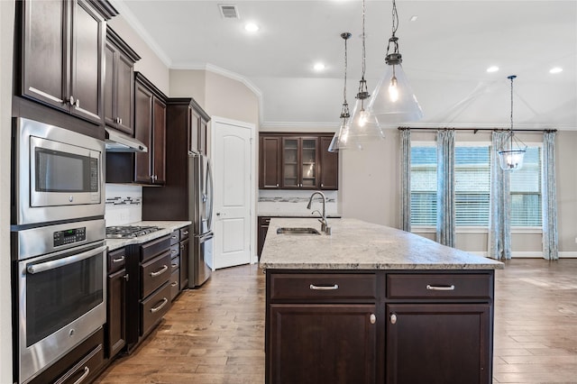 kitchen featuring stainless steel appliances, visible vents, a sink, dark brown cabinetry, and under cabinet range hood