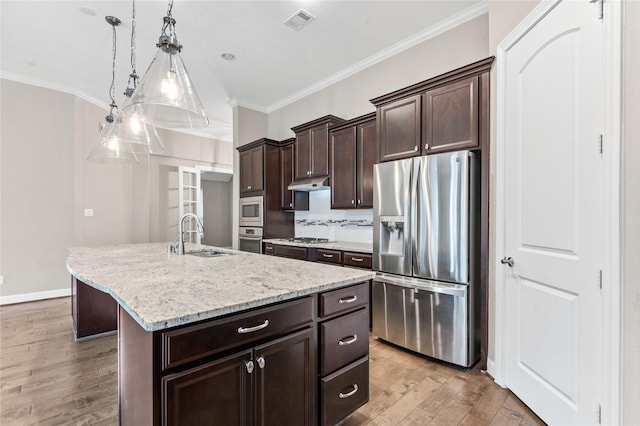 kitchen with visible vents, appliances with stainless steel finishes, ornamental molding, under cabinet range hood, and a sink