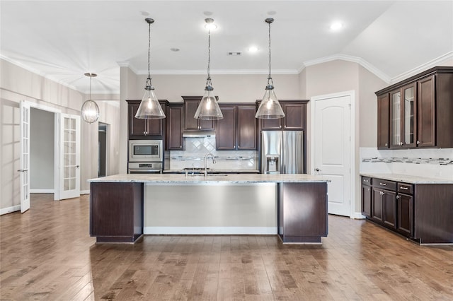 kitchen featuring vaulted ceiling, dark brown cabinets, appliances with stainless steel finishes, and a sink