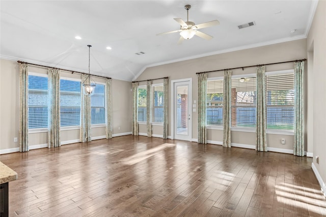 spare room with a wealth of natural light, visible vents, wood finished floors, and ceiling fan with notable chandelier