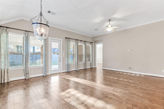 empty room featuring a healthy amount of sunlight, wood finished floors, visible vents, and crown molding