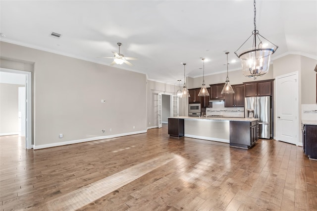 kitchen featuring visible vents, stainless steel appliances, dark brown cabinets, light countertops, and ceiling fan with notable chandelier