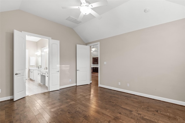 unfurnished bedroom with visible vents, vaulted ceiling, and wood finished floors