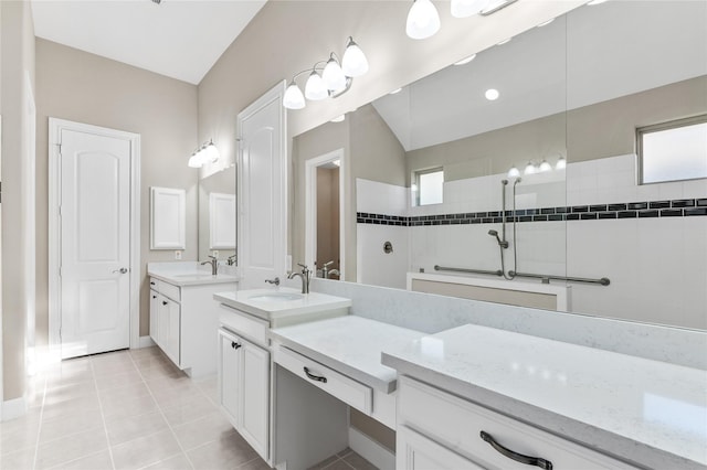 bathroom featuring a walk in shower, two vanities, a sink, and tile patterned floors