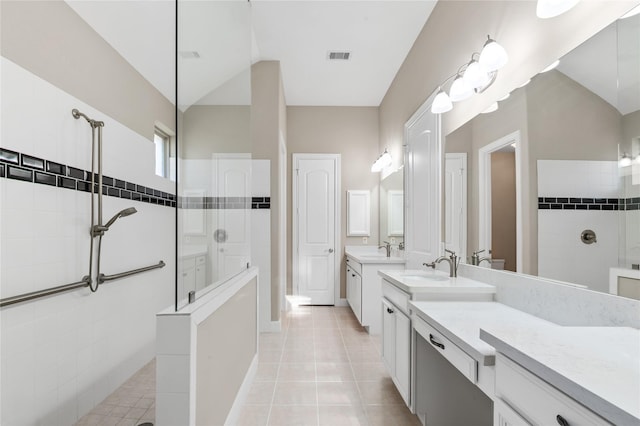 full bath featuring two vanities, a walk in shower, a sink, and tile patterned floors