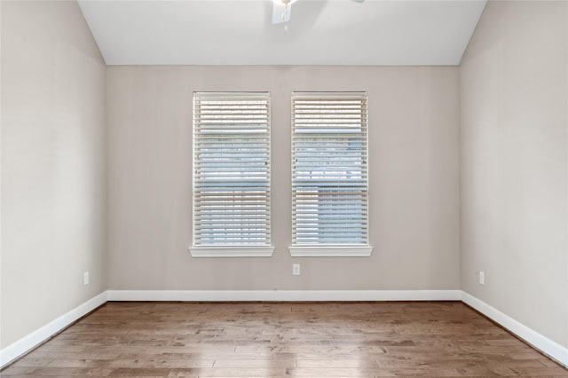 spare room with vaulted ceiling, wood finished floors, and a wealth of natural light